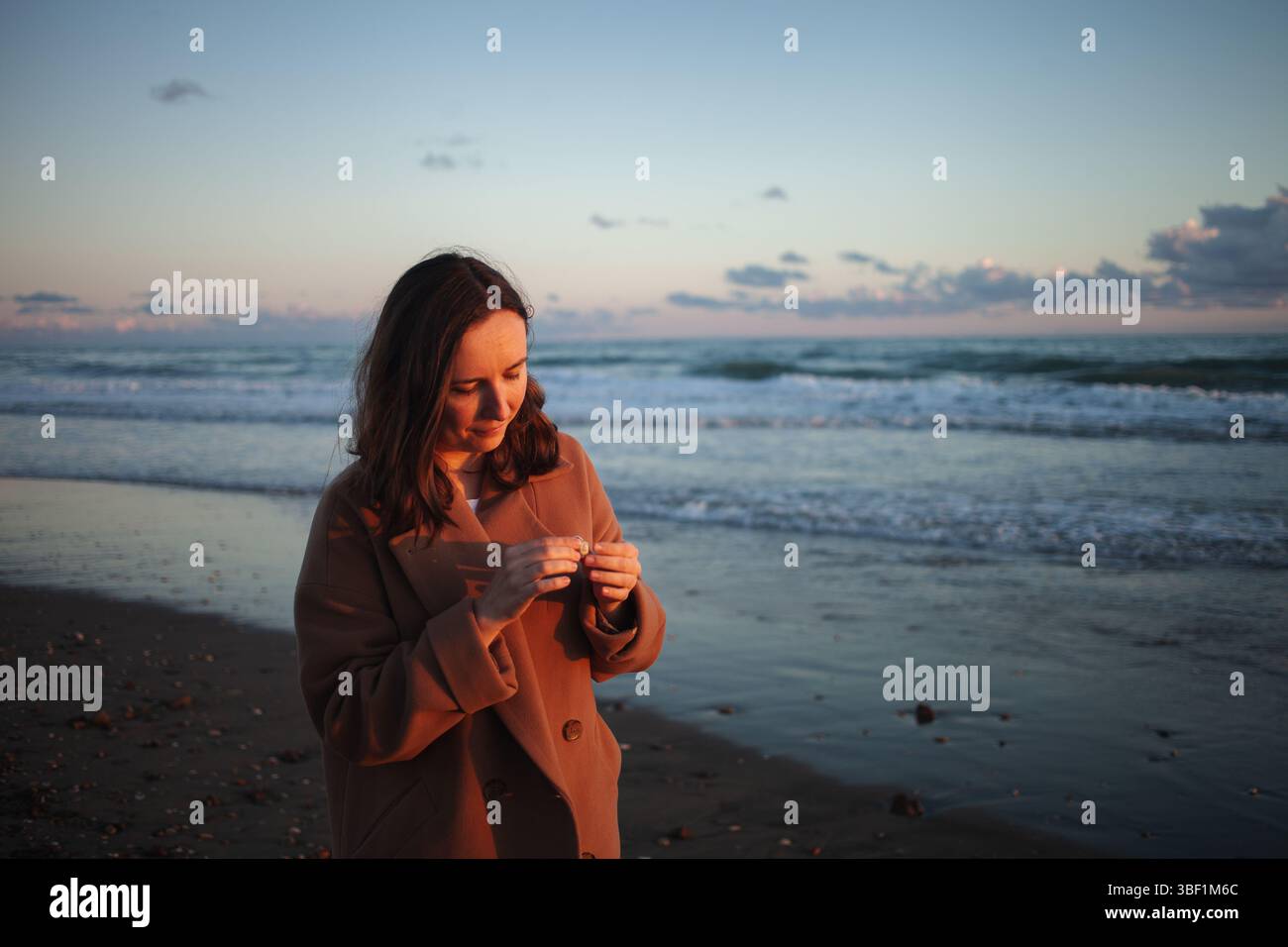 Die Frau macht bei Sonnenuntergang einen gemütlichen Spaziergang Stockfoto