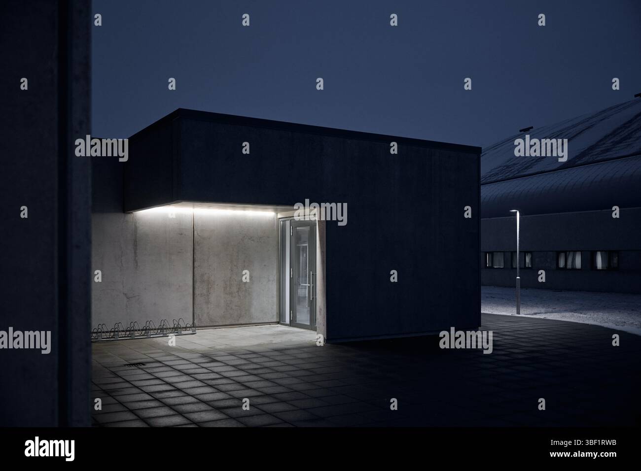 Moderner Gebäudeeingang bei Nacht beleuchtet Stockfoto