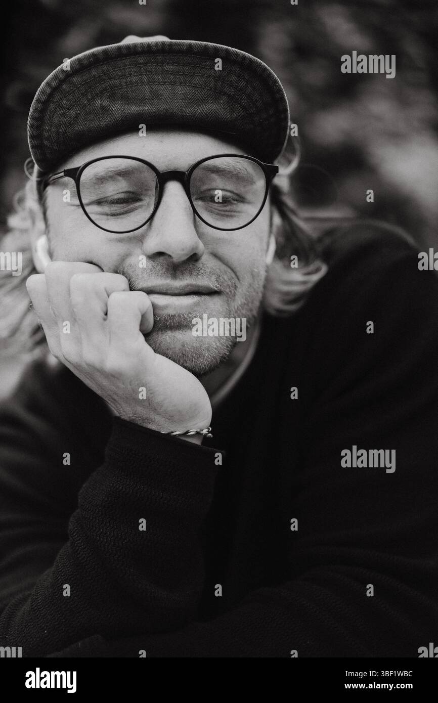 Nahporträt eines Mannes in Brille und Kappe, schwarz-weiß Stockfoto