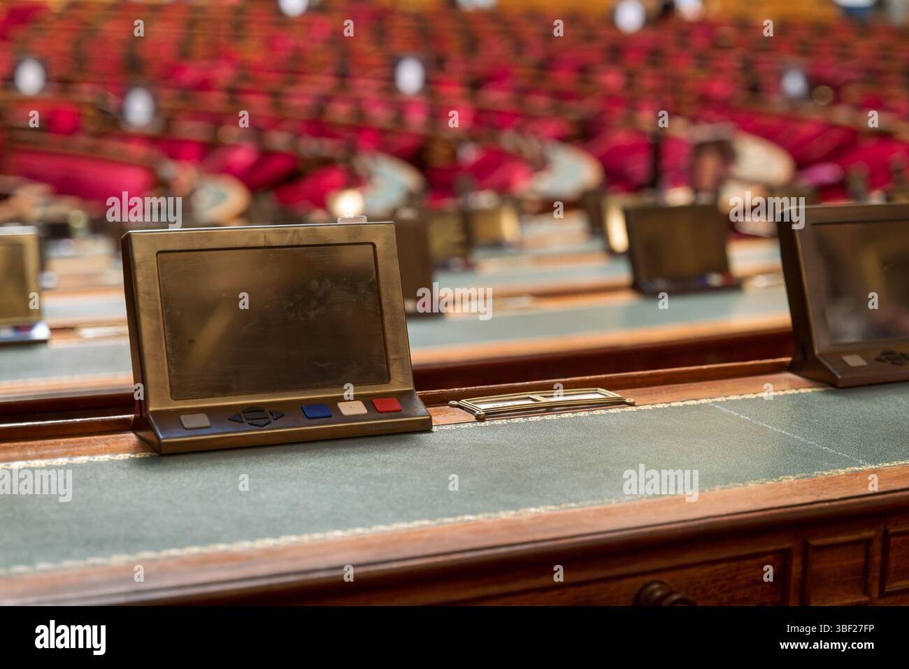 Individuelle Senatortische mit moderner Technik stehen im französischen Senatssaal bereit, mit dem charakteristischen roten gepolsterten Sitzvisier Stockfoto