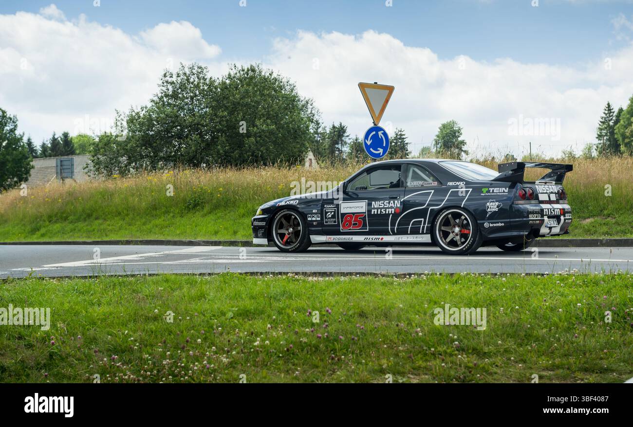 Trafiic im Nürburgring: Seitenansicht der Nissan Skyline R33 GT-R, die sich dem Kreisverkehr nähert Stockfoto