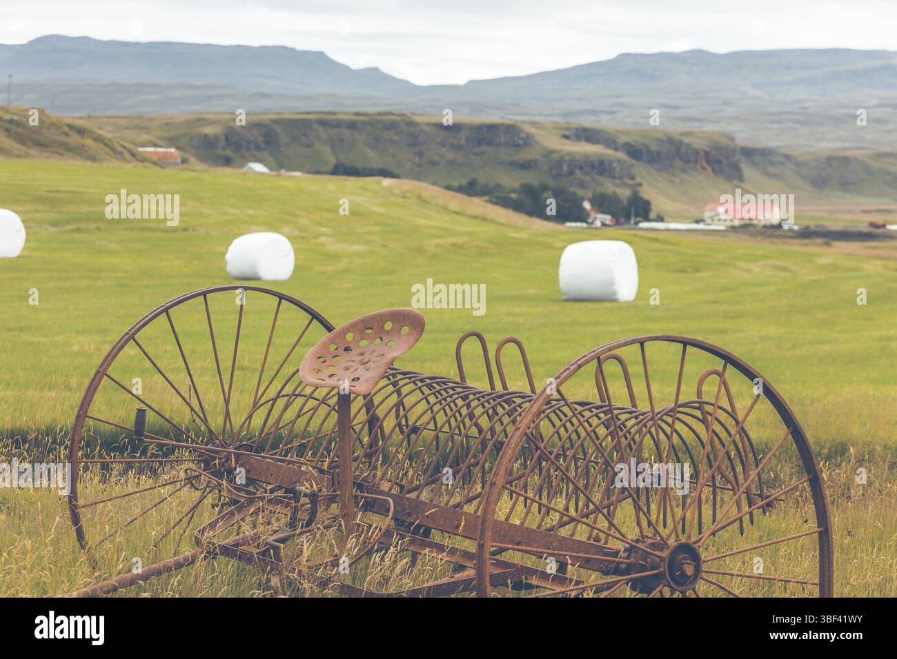 Rusty Traktor Pflügen auf einem Feld von Island Stockfoto