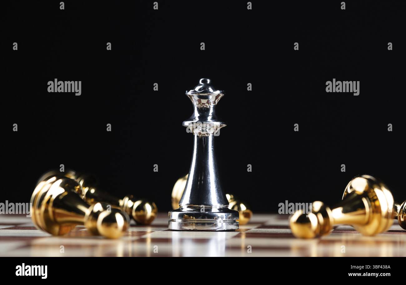 Silberkönigin-Schach besiegt Goldfiguren auf hölzernem Schachbrett. Intellektuelles Duell und taktischer Kampf im Geschäft. Strategieplanung, Führung und Teamarbeit Stockfoto
