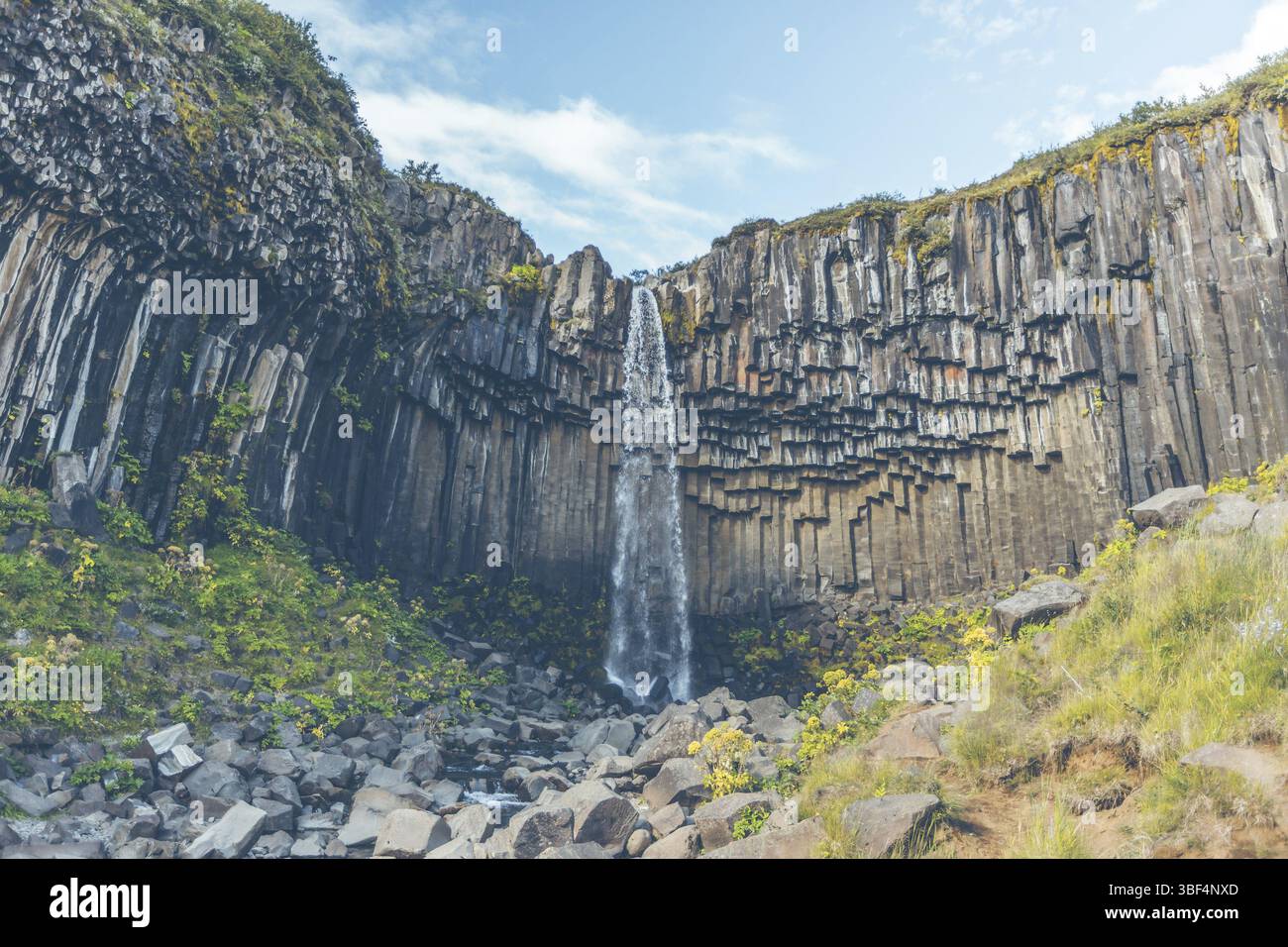 Wasserfall Svartifoss in Island unter einem blauen Himmel mit Wolken Stockfoto