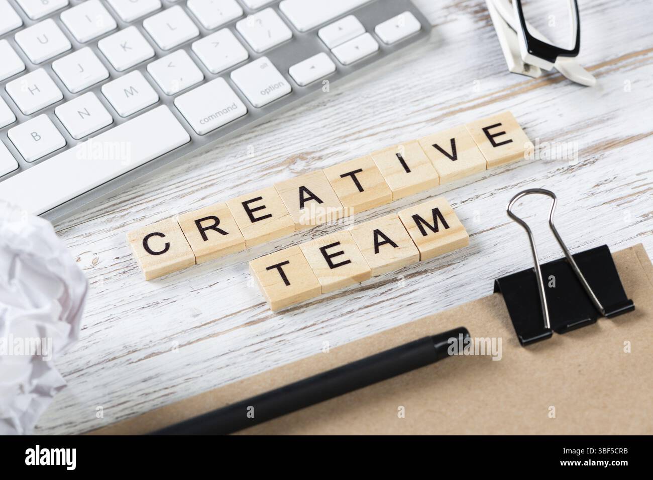 Kreatives Teamkonzept mit Buchstaben auf Würfeln. Stillleben des Büroarbeitsplatzes mit Zubehör. Flacher Vintage-Holztisch mit Computertastatur und nicht Stockfoto