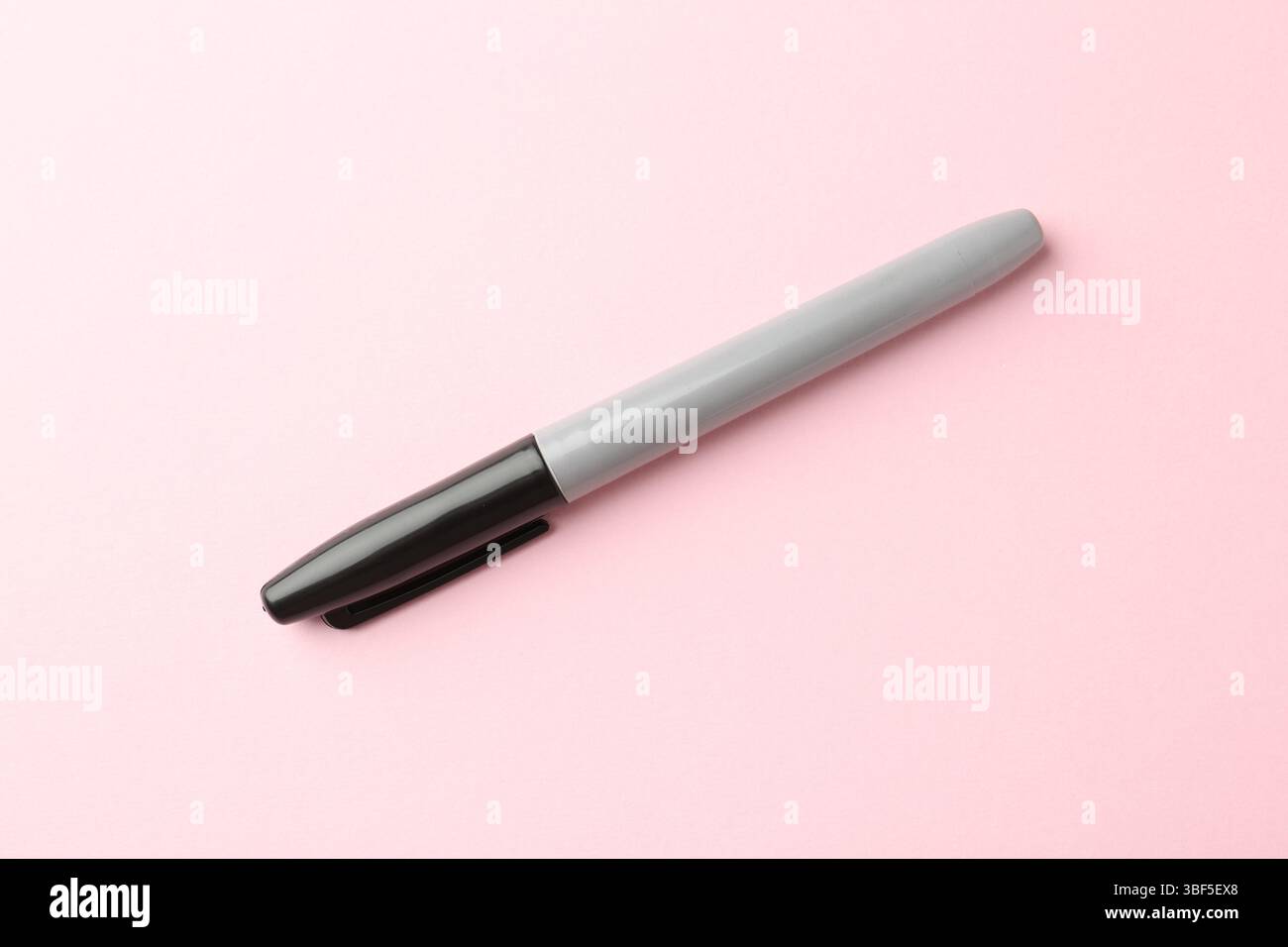Ein schwarzer Marker auf hellrosa Hintergrund, Draufsicht Stockfoto