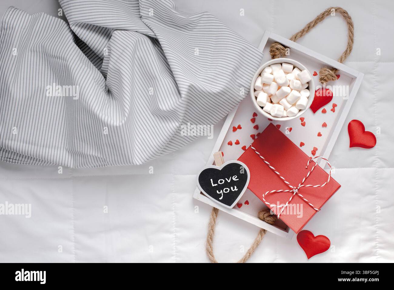 Kreative, oben flach sill Leben romantischen Komposition. Heißer Kakao Kaffee Schokolade mit Marshmallows Becher rot Geschenk herzen Fach im Bett. Konzept Valen Stockfoto