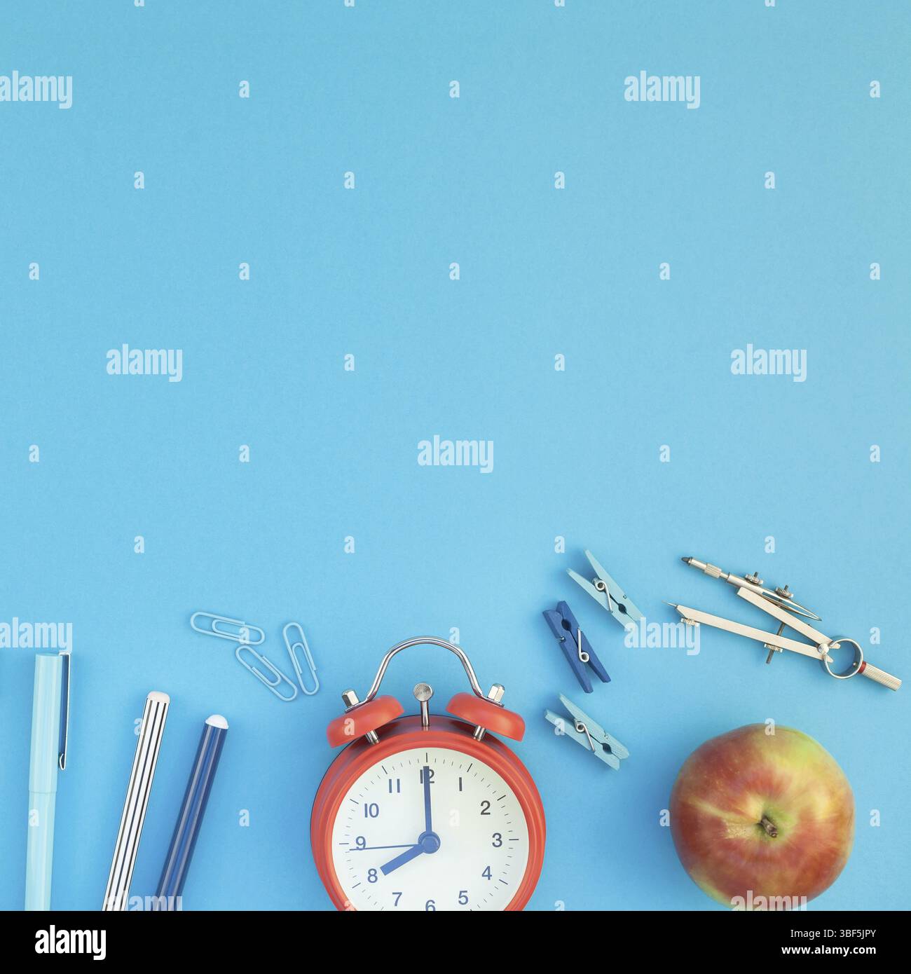 Square Creative flach Draufsicht zurück zu Schule Konzept mit Wecker Farbe Schul- und Büromaterialien auf hell türkis Papier Tischgestell hinterg Stockfoto