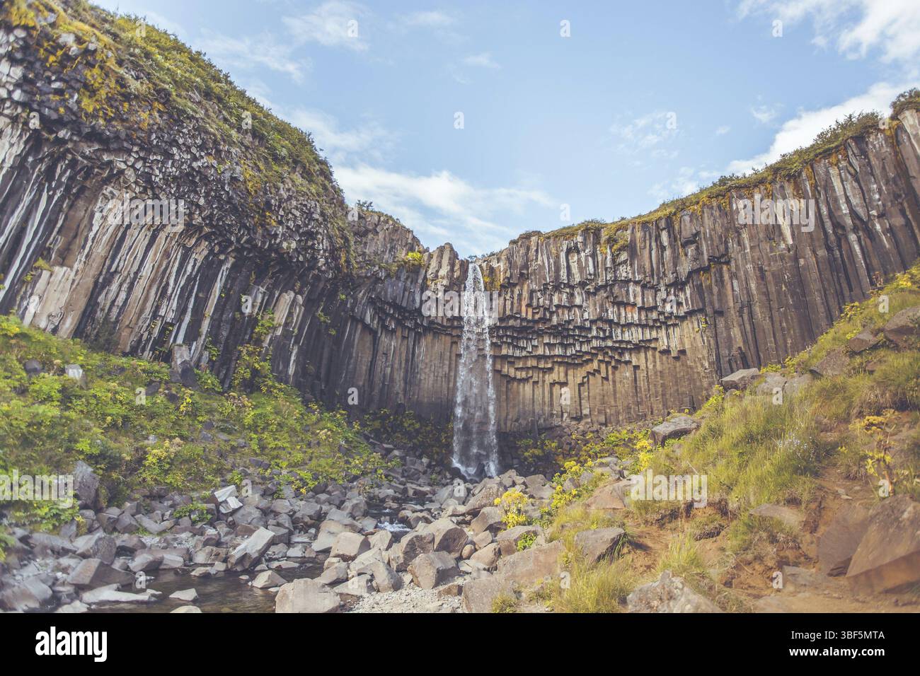 Wasserfall Svartifoss in Island unter einem blauen Himmel mit Wolken Stockfoto
