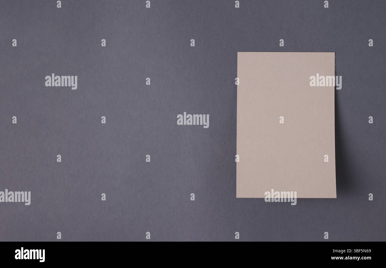Leeres Papier für Ansagen, hängt an dunkelgrauer Wand, Modell, Platz für Text Stockfoto
