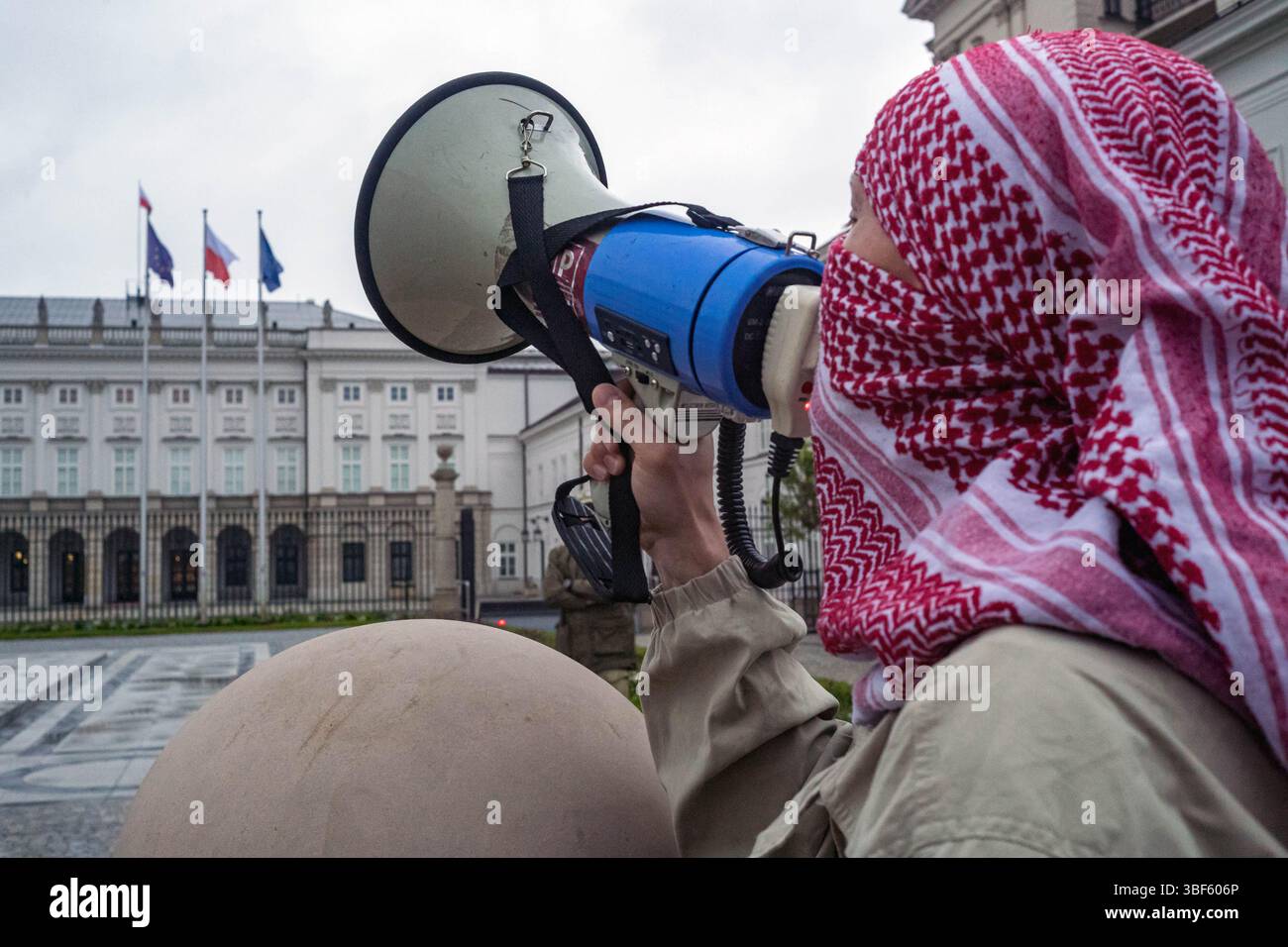 Ein Demonstrant, der einen keffiyeh-Gesang-Slogan durch ein Megaphon trug, während einer Demonstration vor dem Präsidentenpalast. Am Freitag, dem 30. Mai, versammeln sich eine Gruppe palästinensischer Aktivisten und Demonstranten im polnischen Präsidentenpalast in Warschau. Die Demonstranten tragen Banner, Plakate und Fahnen und versuchen, die Präsidentschaftskandidaten an die Präsidentschaftswahlen am Sonntag und ihre Wähler daran zu erinnern, dass der Völkermord in Gaza ein lebendiges und dringliches Thema ist. UN-Generalsekretär Antonio Guterres hat erklärt, dass "die Lage der Palästinenser im Gazastreifen unbeschrieben ist, Mo Stockfoto