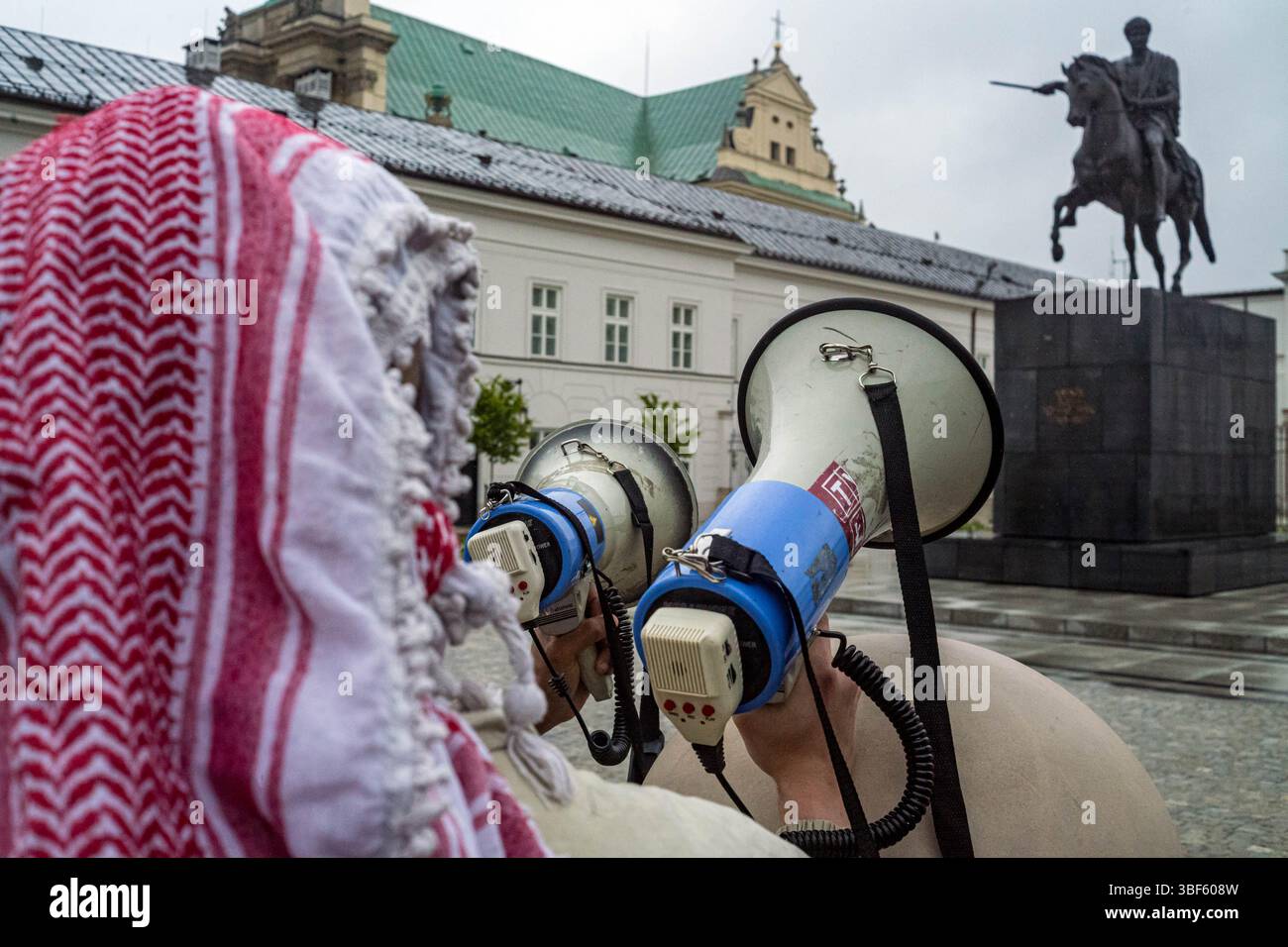 Ein Demonstrant, der einen keffiyeh-Gesang-Slogan durch ein Megaphon trug, während einer Demonstration vor dem Präsidentenpalast. Am Freitag, dem 30. Mai, versammeln sich eine Gruppe palästinensischer Aktivisten und Demonstranten im polnischen Präsidentenpalast in Warschau. Die Demonstranten tragen Banner, Plakate und Fahnen und versuchen, die Präsidentschaftskandidaten an die Präsidentschaftswahlen am Sonntag und ihre Wähler daran zu erinnern, dass der Völkermord in Gaza ein lebendiges und dringliches Thema ist. UN-Generalsekretär Antonio Guterres hat erklärt, dass "die Lage der Palästinenser im Gazastreifen unbeschrieben ist, Mo Stockfoto