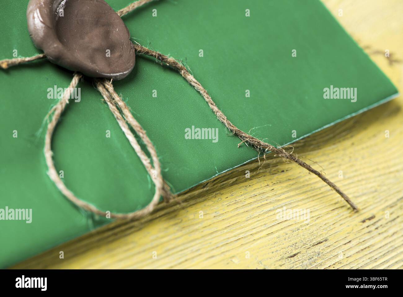 Grüner Briefumschlag mit Wachssiegel auf der Holzoberfläche Stockfoto