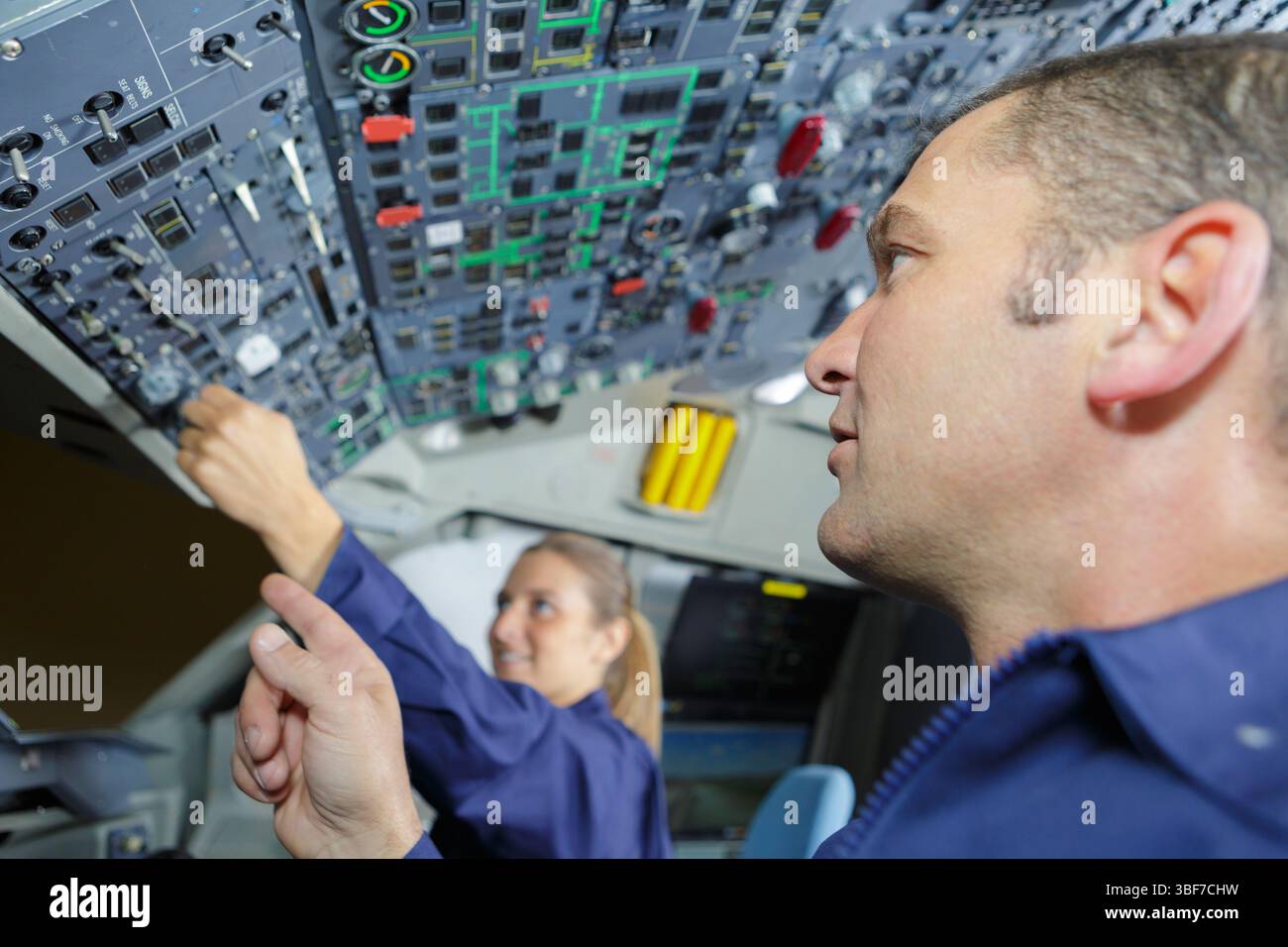 Weibliche Auszubildende, die Bedienelemente im Cockpit bedienen Stockfoto