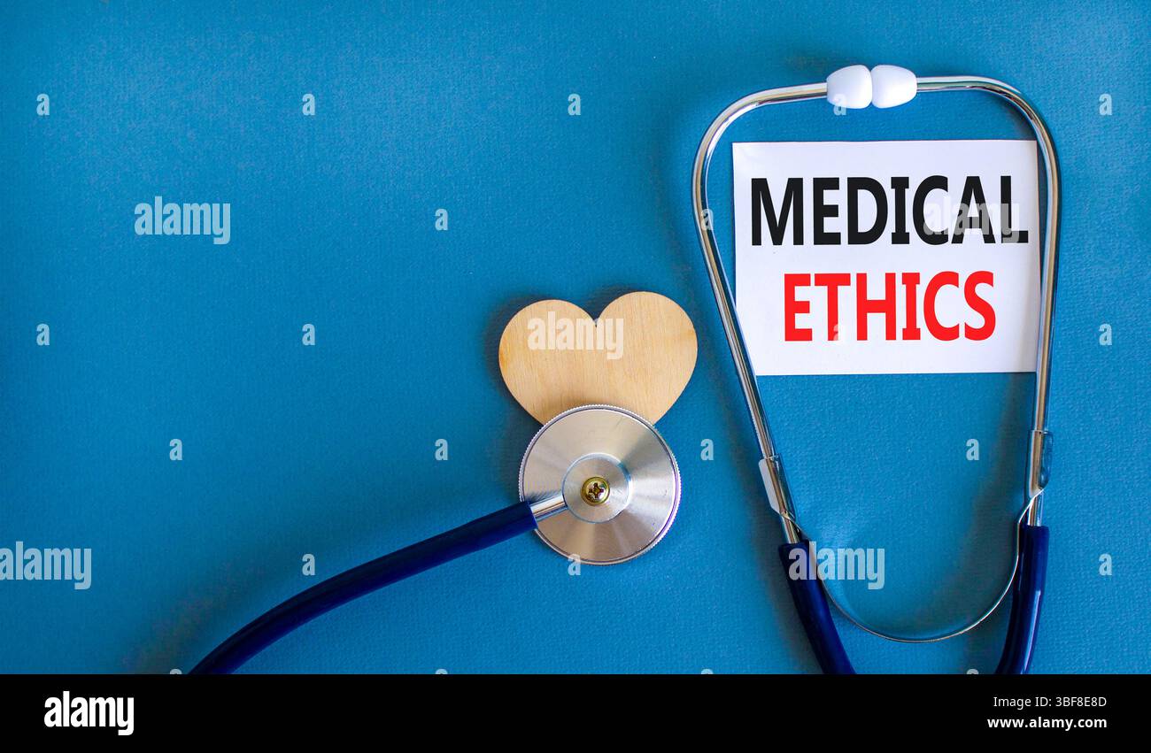 Medizinethik-Symbol. Konzeptworte medizinische Ethik auf der schönen weißen Karte. Holzherz und Stethoskop. Wunderschöner blauer Hintergrund. Medizinisch gesund Stockfoto