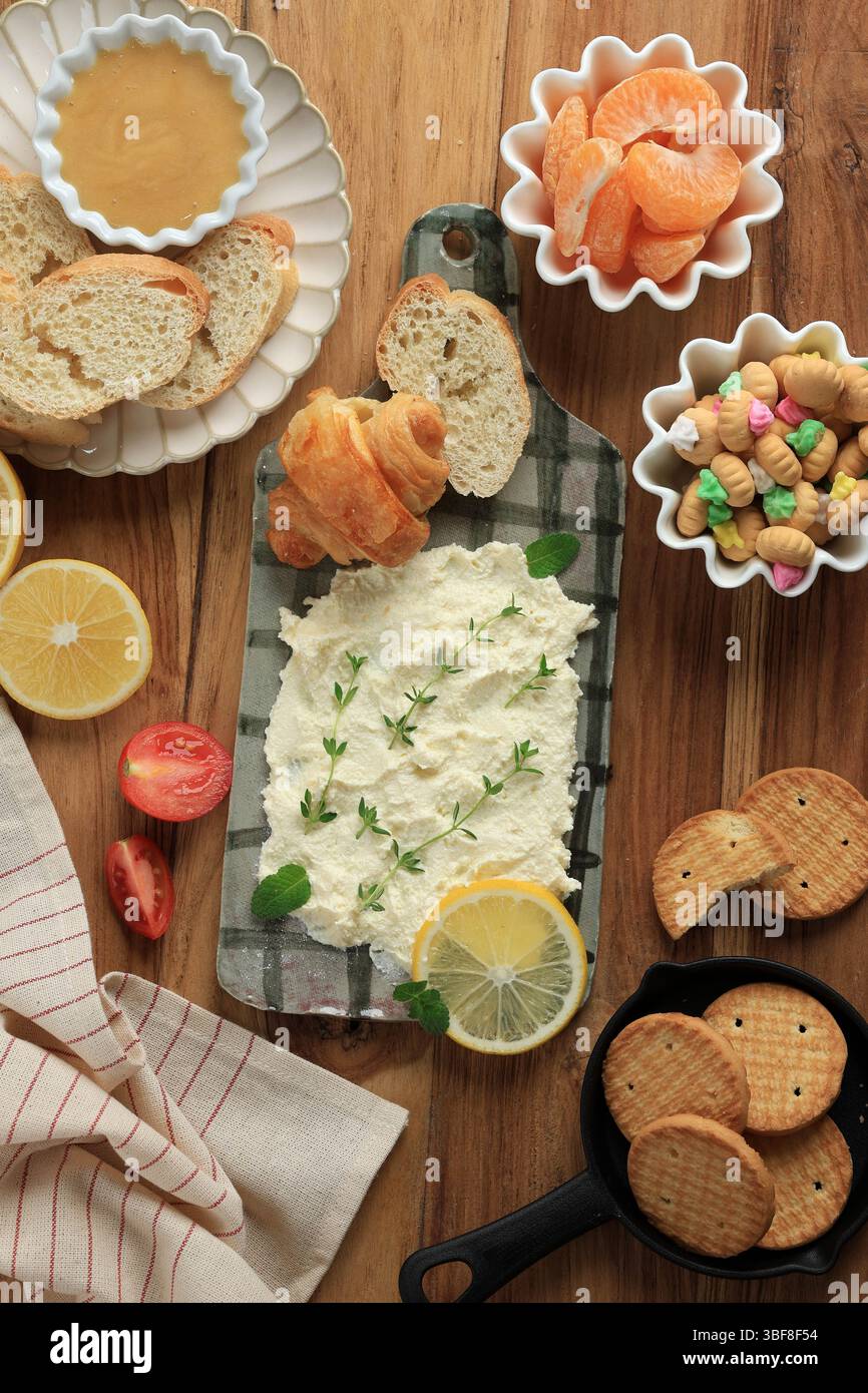 Top View hausgemachte Butterplatte mit frischer Orange, Cookies und Mini Croissant. Stockfoto