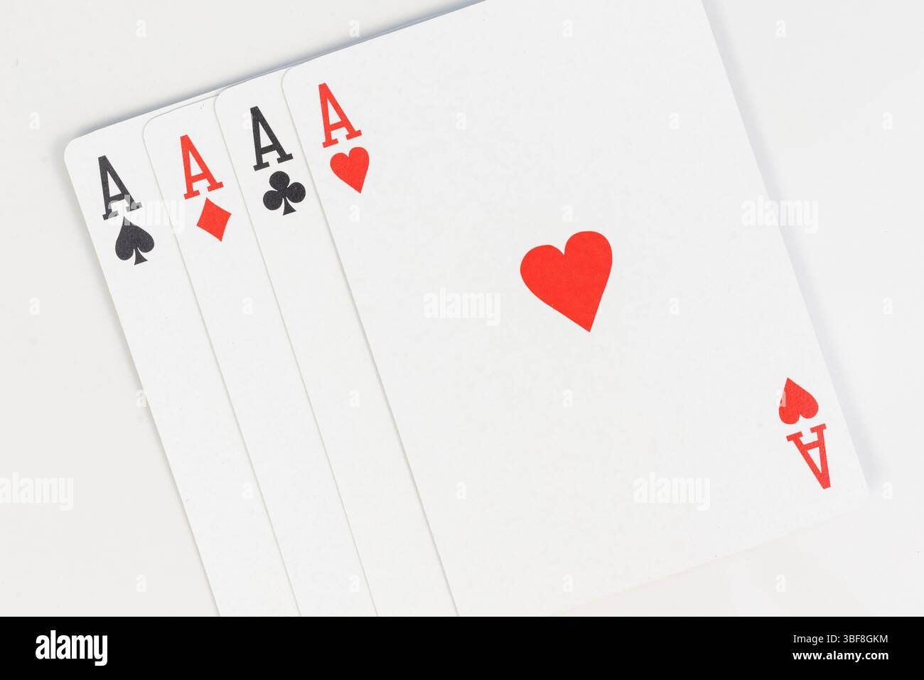 Vier Spielkarten mit Pik-Ass, Diamanten-Asse, Clubs-Asse und Herz-Asse auf weißem Hintergrund Stockfoto