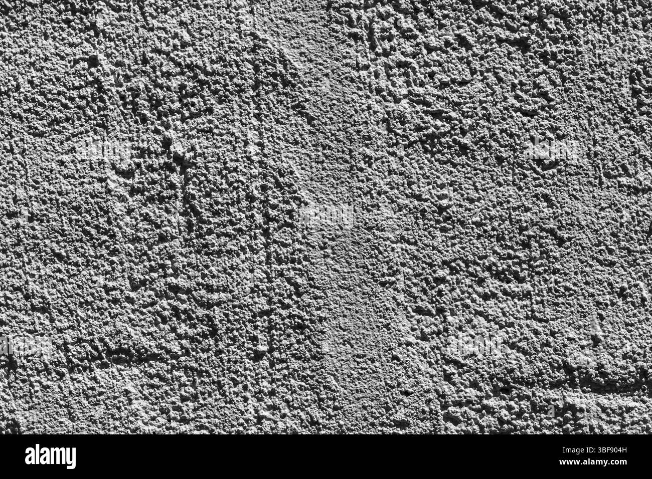 Nahaufnahme einer grauen Stuckwand mit einer strukturierten Oberfläche mit einem etwas glatteren vertikalen Bereich in der Mitte. Stockfoto