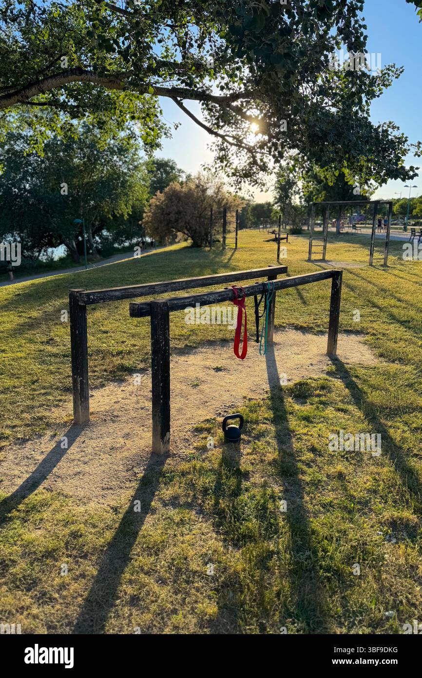 Mobilitäts- und Krafttrainingsgeräte in einem Park bei Sonnenuntergang Stockfoto