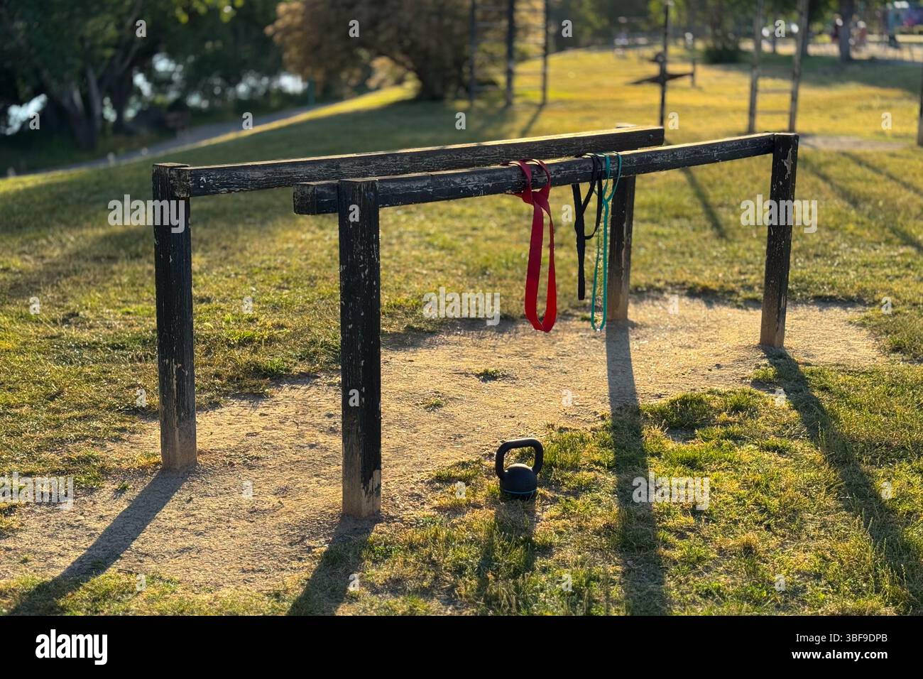 Mobilitäts- und Krafttrainingsgeräte in einem Park bei Sonnenuntergang Stockfoto