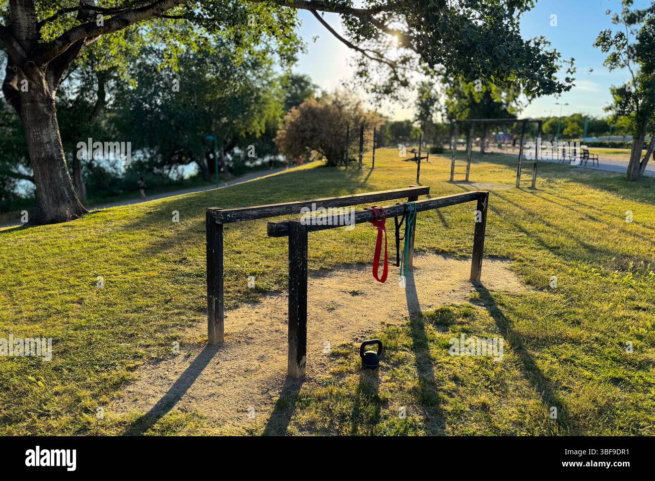 Mobilitäts- und Krafttrainingsgeräte in einem Park bei Sonnenuntergang Stockfoto