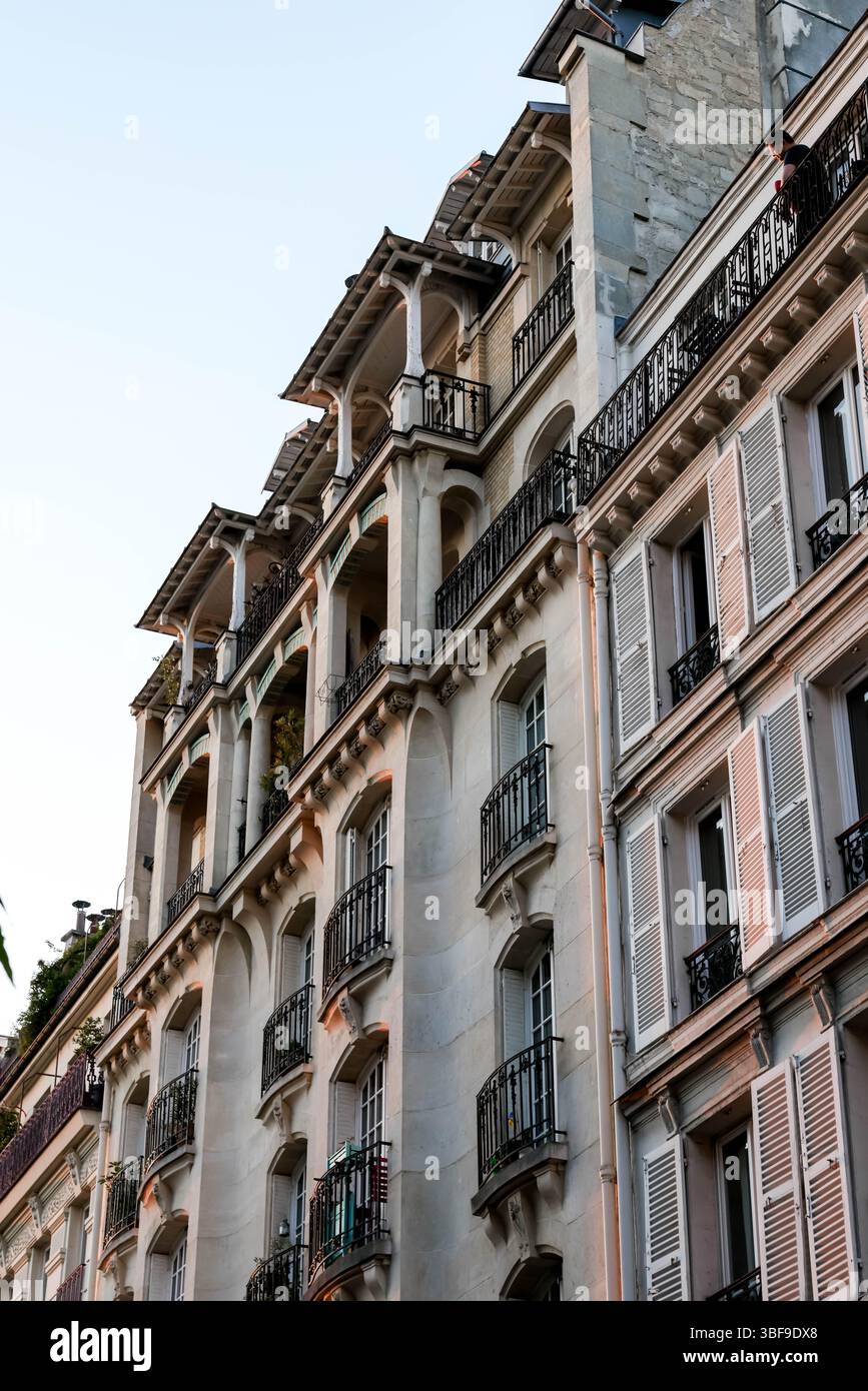 Ein beeindruckender Aufwärtswinkel unterstreicht die elegante Architektur eines klassischen Pariser Gebäudes mit seinem markanten Mansardendach, Stockfoto