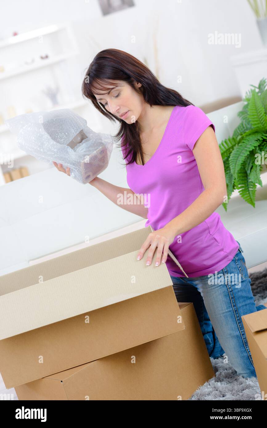 Frau, die Sachen in Pappkartons packt Stockfoto