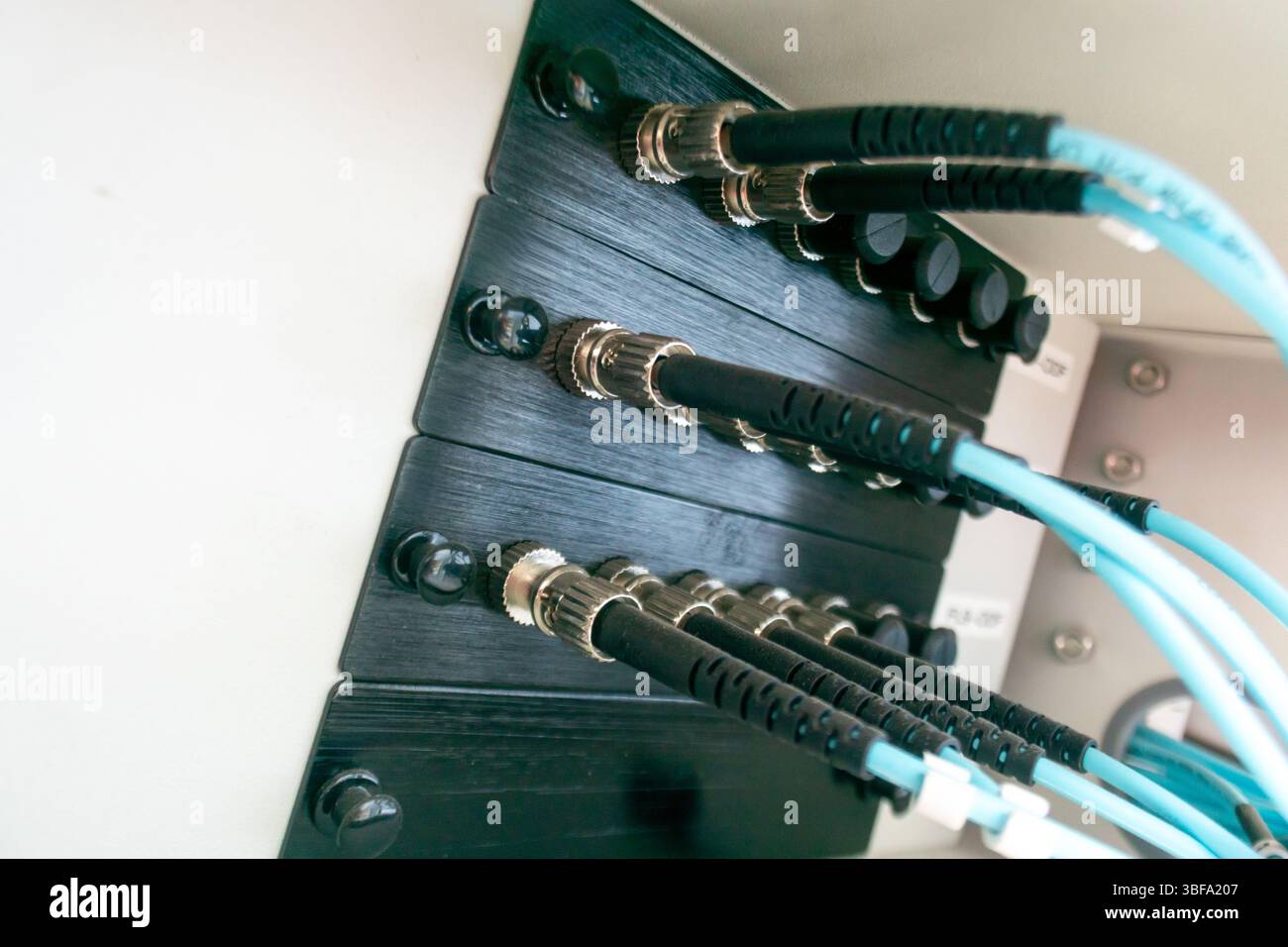 Nahansicht mit Netzwerkkabelverbindungen und Hardware. Das Bild hebt verschiedene Anschlüsse und Drähte in einer Technologie-Einrichtung hervor und hebt die Daten hervor Stockfoto