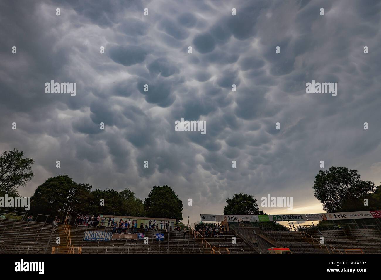 Am Nachmittag kommt es zu Regen im Siegerland. Mammatus-Wolken am Himmel ueber dem Siegener Leimbachstadion. Im Vordergrund eine Tribuene. Fruehling Frühling im Siegerland am 31.05.2025 in Siegen/Deutschland. *** Nachmittags kommt es zu Regen im Siegerland Mamma Wolken am Himmel über dem Siegen Leimbachstadion im Vordergrund ein Tribun-Frühlingsbrunnen im Siegerland am 31 05 2025 in Siegen Deutschland Stockfoto