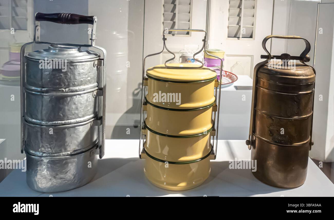 Tiffin-Träger, Dabba, Lunchbox (von links nach rechts: Aluminium, Emaille, Kupfer). Melaka, Malaysia Stockfoto