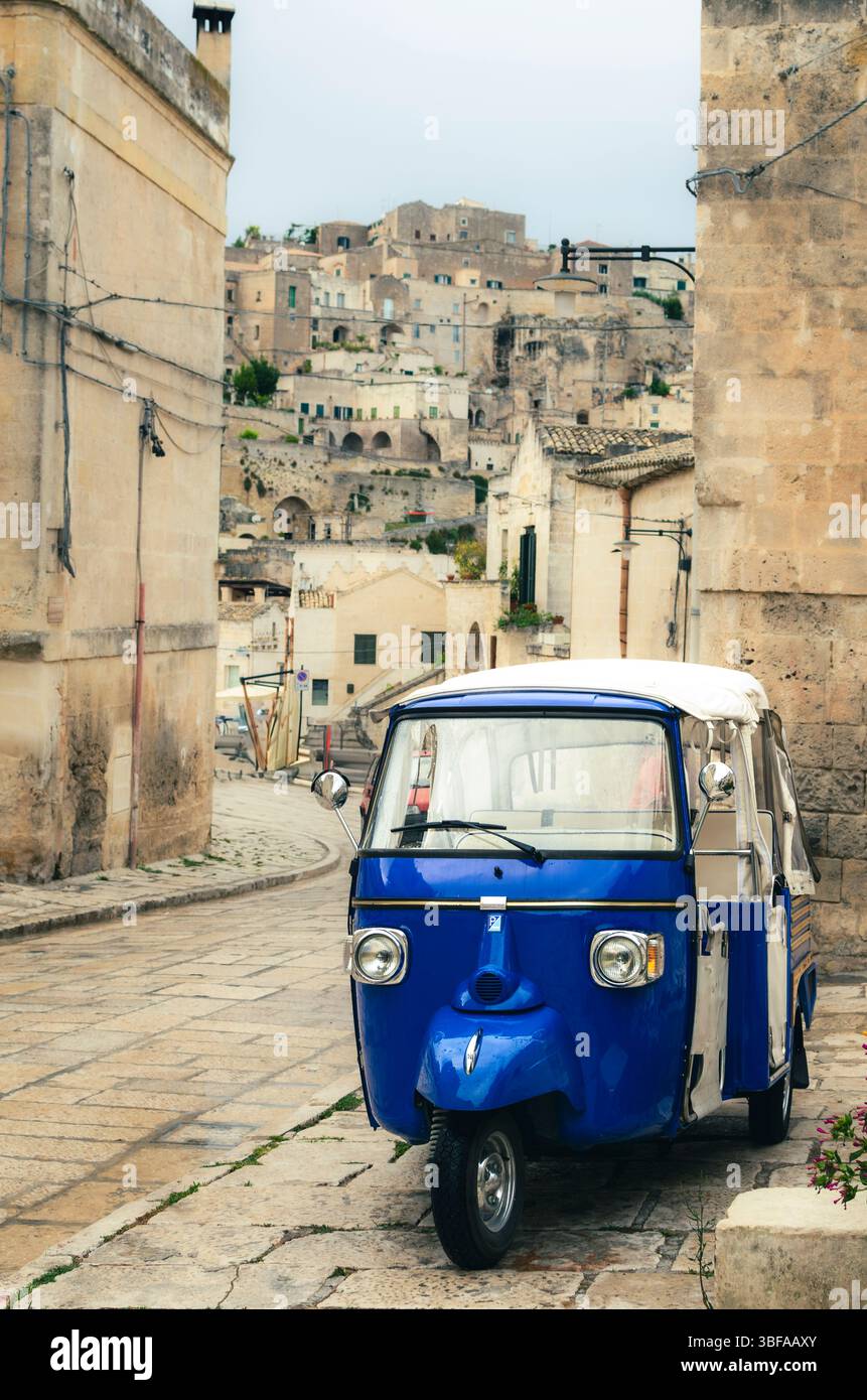 Die „Sassi“-Steine von Matera. Das berühmte Ape Taxi oder „Calessino“, das Menschen auf diesen mittelalterlichen Straßen bewegen kann. Stockfoto