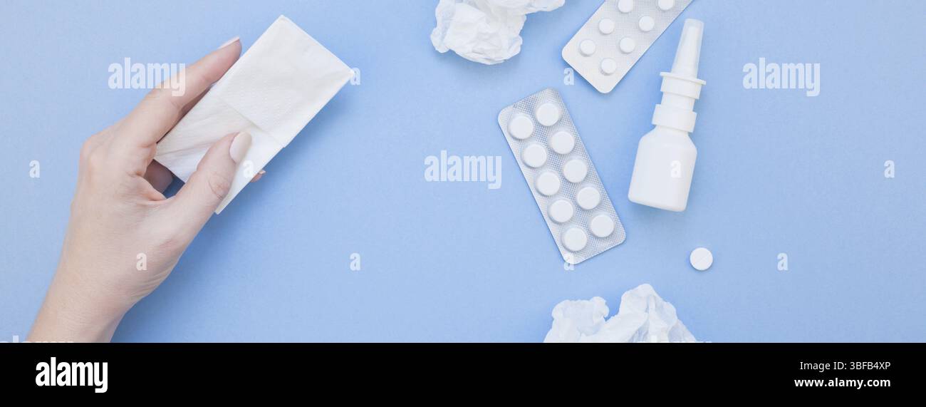 Kreative flach Konzept der saisonale Frühling Allergie mit Servietten, Pillen, Gesichtsmaske, Tropfen in einer Flasche und eine weibliche Hand mit Kopie Raum lange breite Verbot Stockfoto