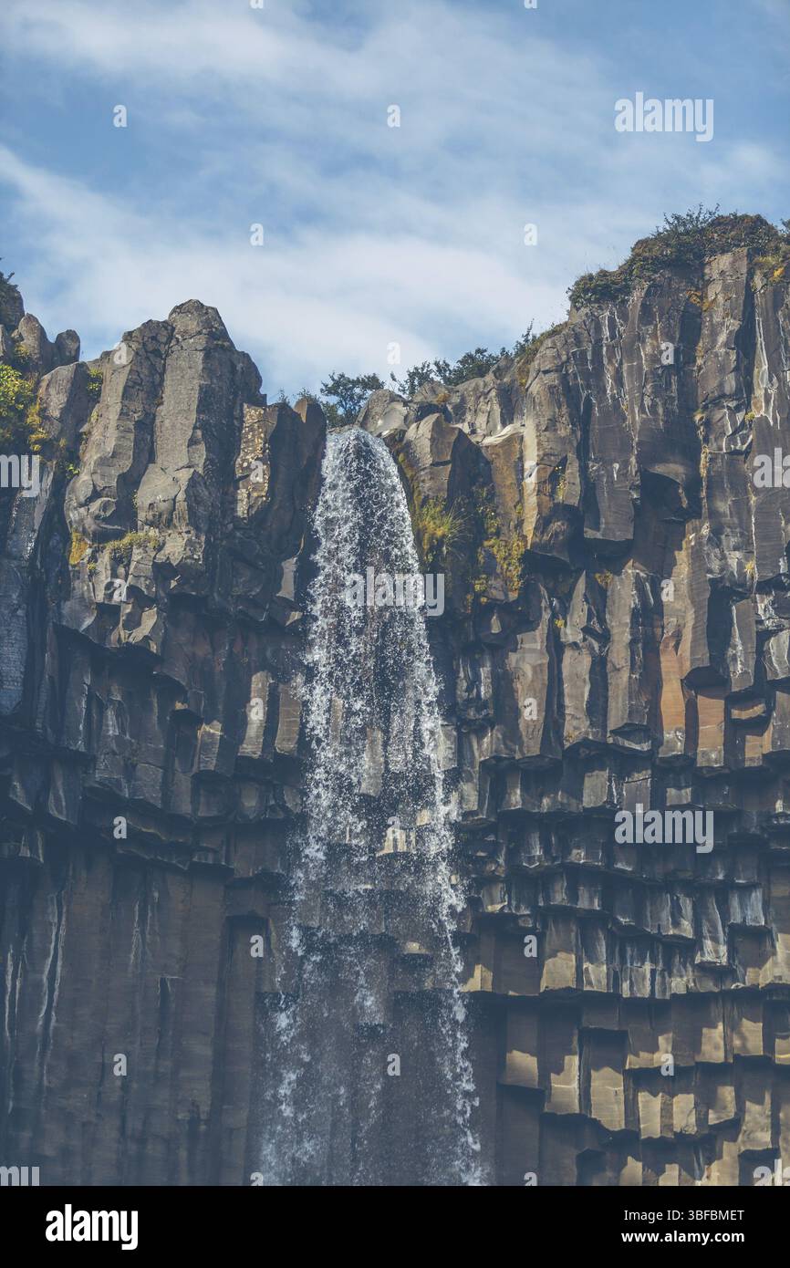 Wasserfall Svartifoss in Island unter einem blauen Himmel mit Wolken Stockfoto