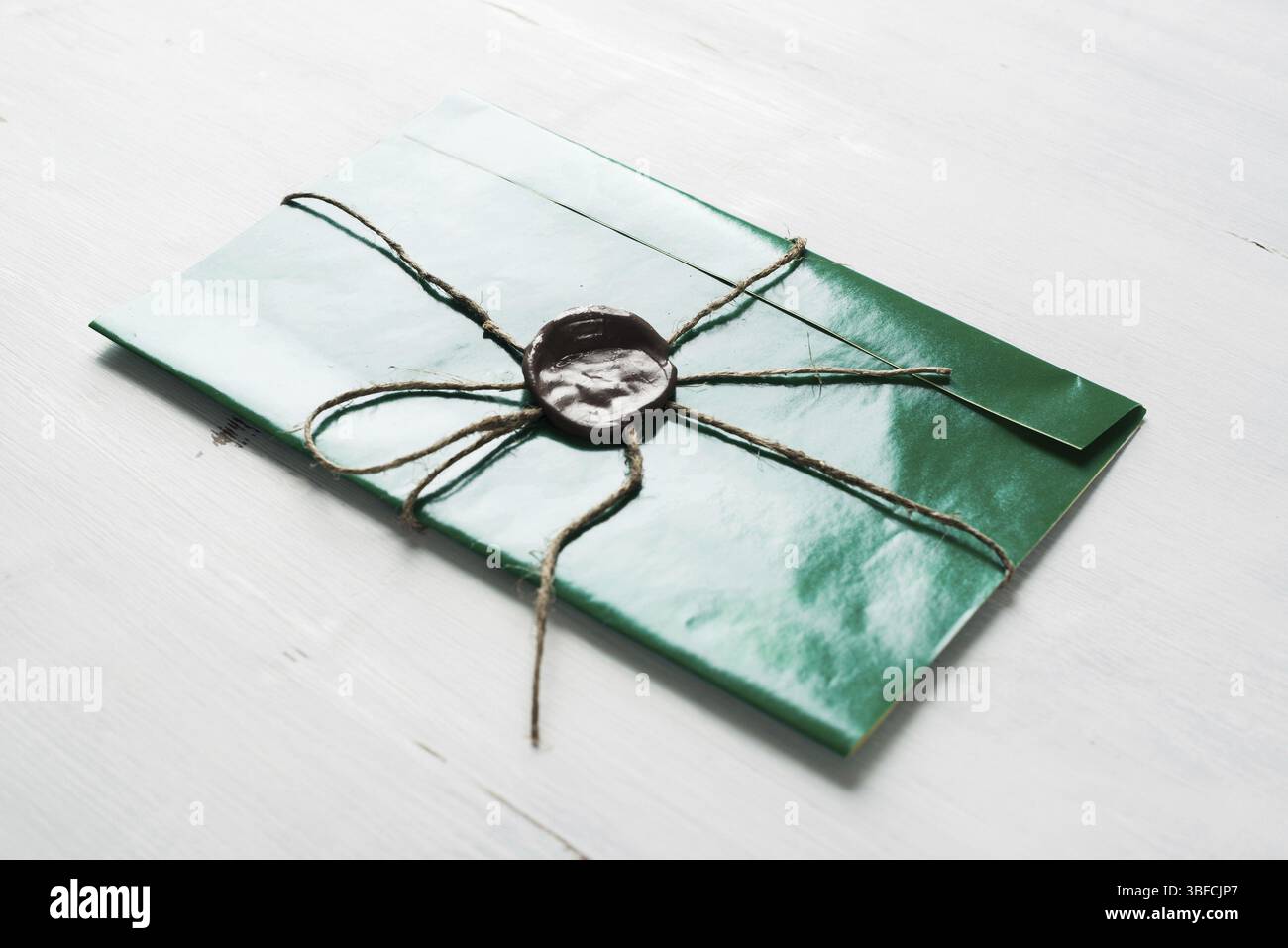 Grüner Briefumschlag mit Wachssiegel auf der Holzoberfläche Stockfoto