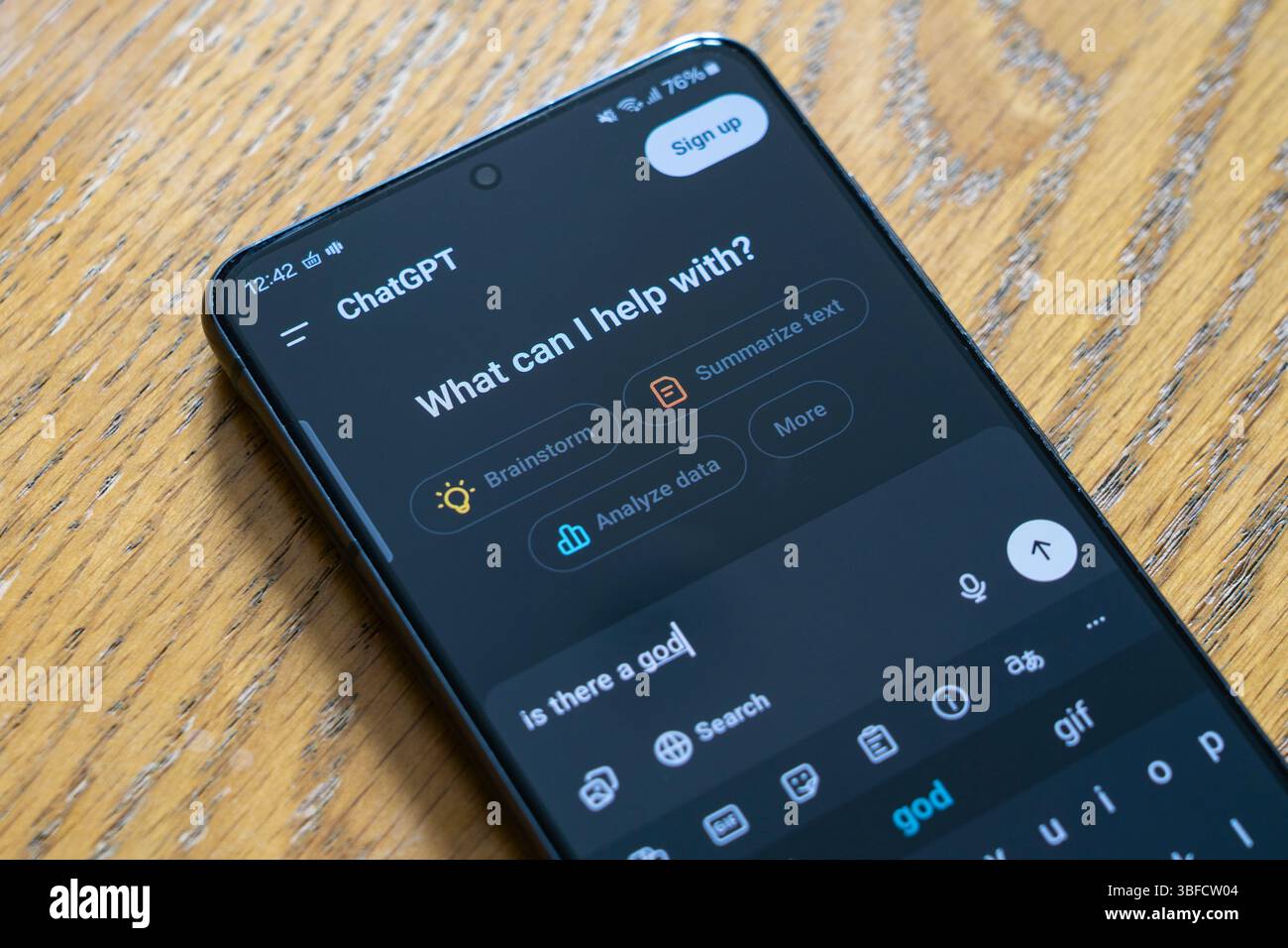 Chatten Sie GPT auf einem Smartphone und fragen Sie „Was kann ich helfen?“, und stellen Sie sich eine Endnutzerfrage mit der Frage „gibt es einen Gott?“, Großbritannien. Konzept: generative KI, Philosophie Stockfoto