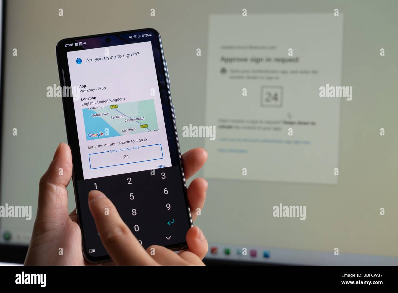 Eine Frau, die von zu Hause aus arbeitet und eine Nummer in der Microsoft Authenticator App für die 2-Faktor-Authentifizierung (2FA) für den Zugriff auf die Workday App eingibt. UK Stockfoto