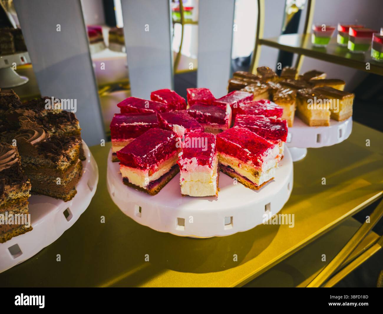 Verschiedene Gourmet-Kuchen auf weißen Ständen in eleganter Dessertpräsentation Stockfoto