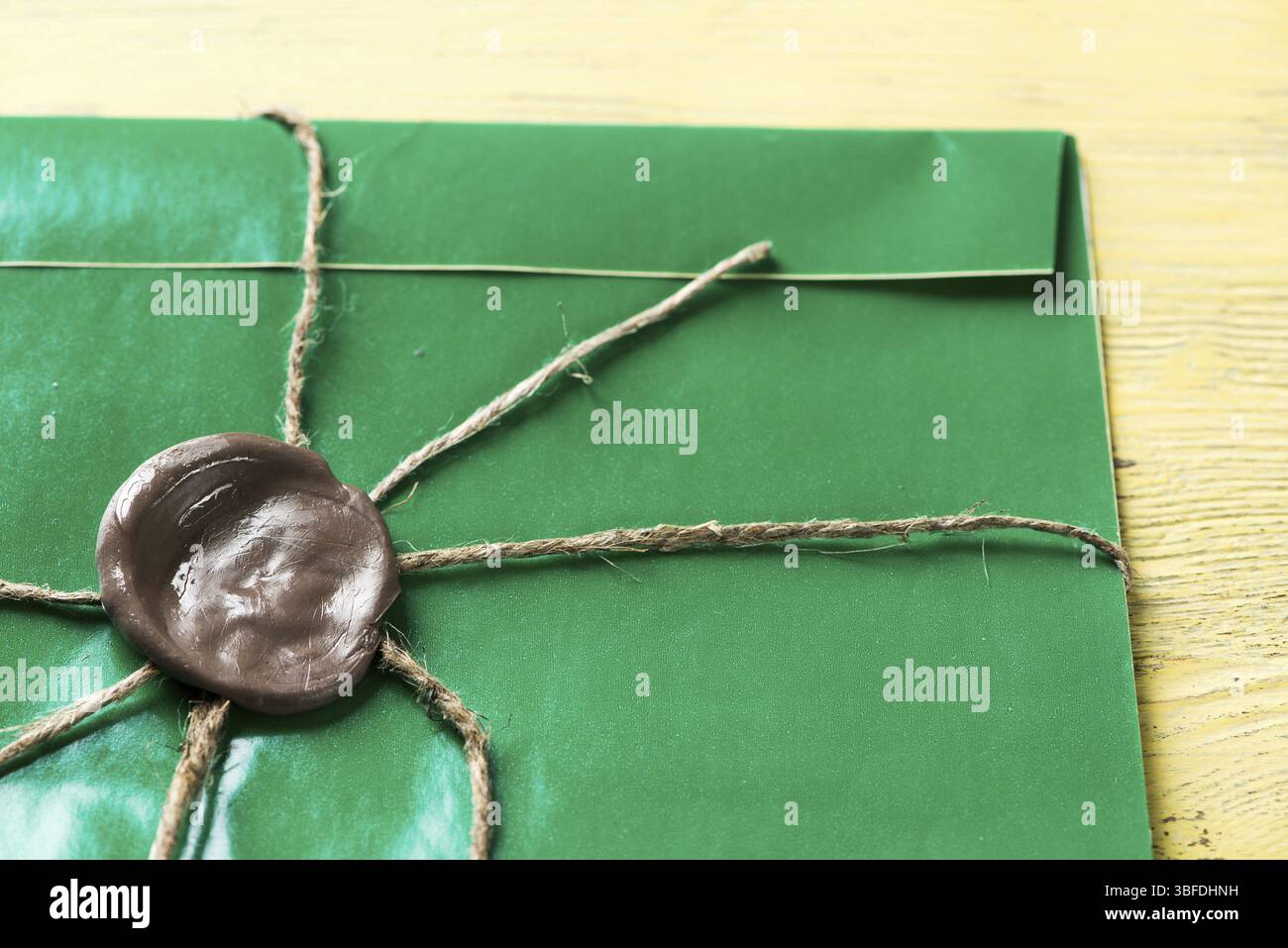 Grüner Briefumschlag mit Wachssiegel auf der Holzoberfläche Stockfoto