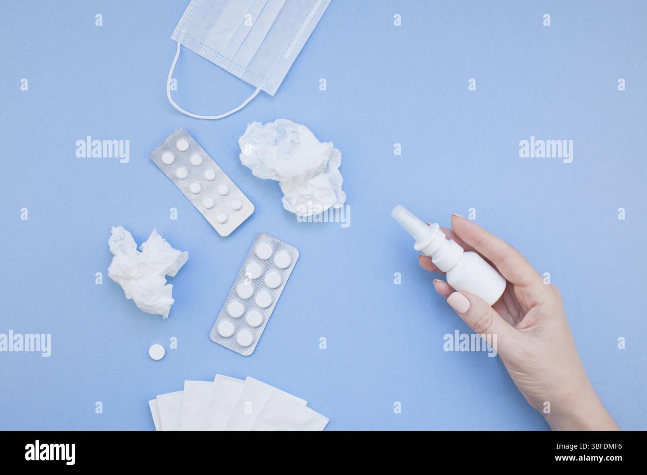 Kreative flach Konzept der saisonale Frühling Allergie mit Servietten, Pillen, Gesichtsmaske, Tropfen in einer Flasche und eine weibliche Hand mit Kopie Raum Hintergrund mi Stockfoto