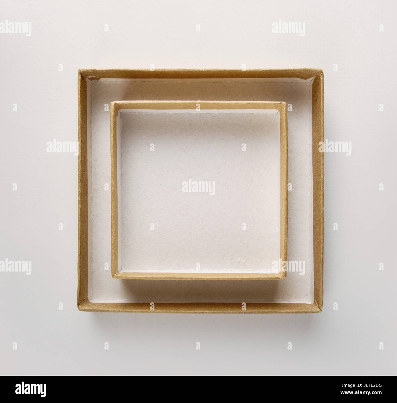 Rahmen an weißer Wand aus zwei quadratischen Bastelboxen, Modell, Kopierraum Stockfoto