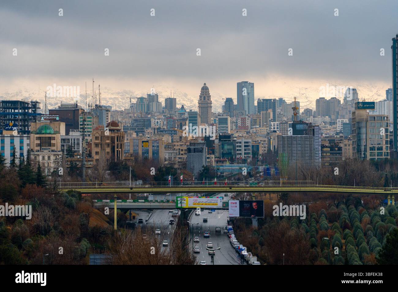Teheran, Iran - 12. November 2023: Stadtbild Teherans mit dichten Gebäuden und schneebedeckter Bergkulisse Stockfoto