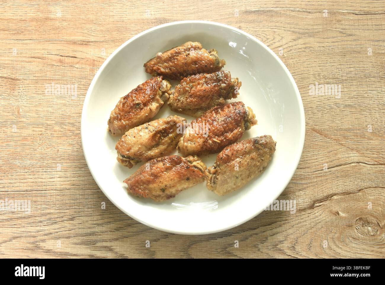Gegrillter salziger und scharfer Hähnchenflügel mit schwarzem Pfeffer auf Teller Stockfoto