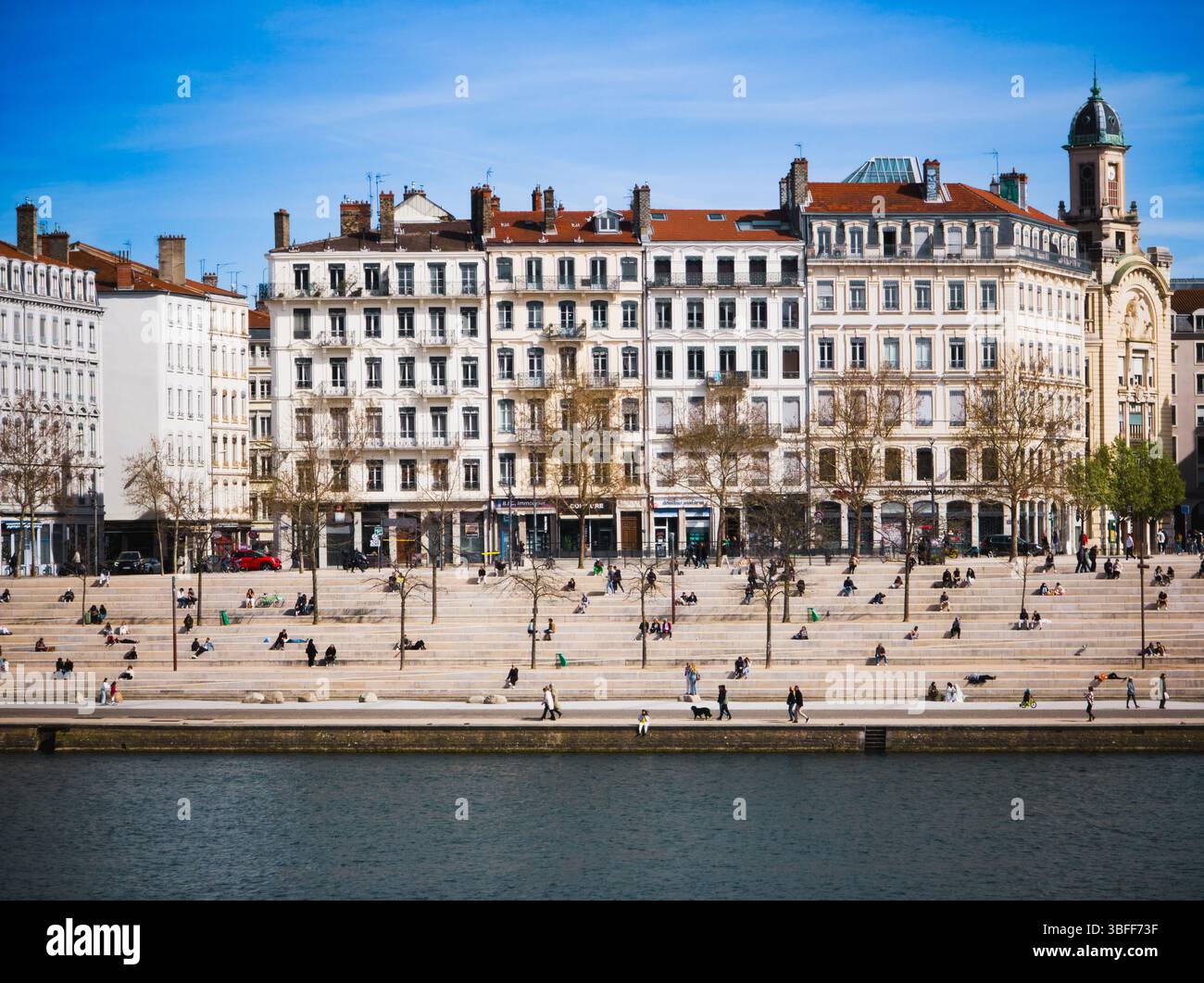 Entspanntes Stadtleben auf den urbanen Stufen am Flussufer in Lyon, Frankreich – 30. März 2025 Stockfoto