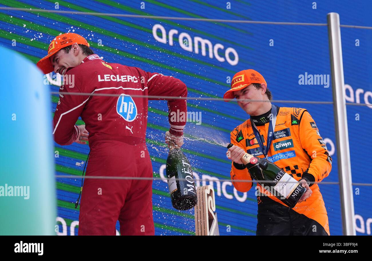 McLaren Oscar Piastri sprüht Ferraris Charles Leclerc mit Champagner auf das Podium, nachdem er auf dem Circuit de Barcelona-Catalunya, Spanien, den ersten Platz im Rennen belegte. Bilddatum: Sonntag, 1. Juni 2025. Stockfoto