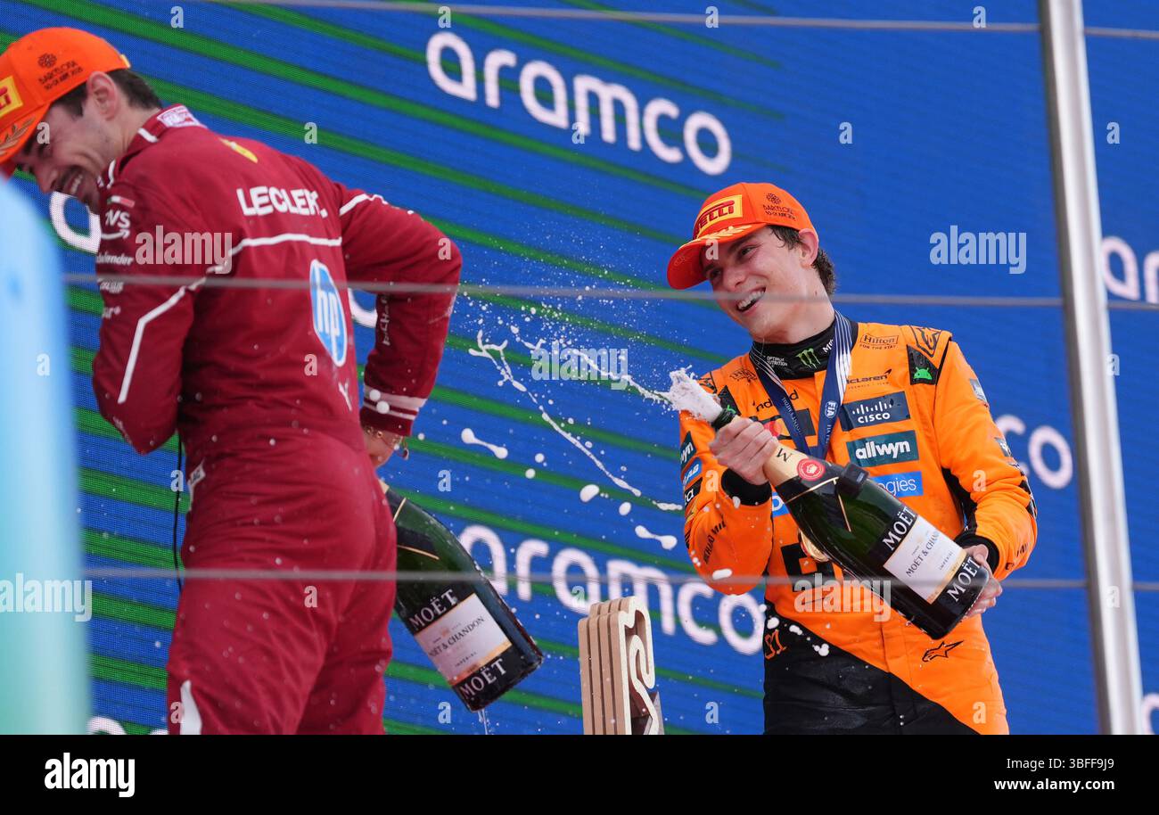 McLaren Oscar Piastri sprüht Ferraris Charles Leclerc mit Champagner auf das Podium, nachdem er auf dem Circuit de Barcelona-Catalunya, Spanien, den ersten Platz im Rennen belegte. Bilddatum: Sonntag, 1. Juni 2025. Stockfoto