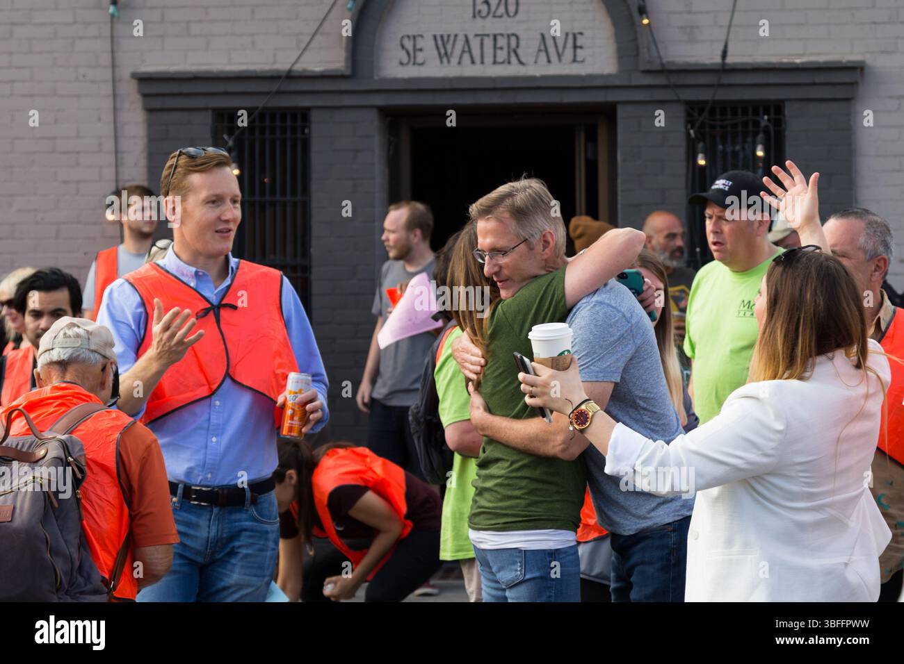 Portland, Oregon – 17. August 2017: Menschen versammeln sich außerhalb der 1320 SE Water Ave, einige tragen orangefarbene Westen, aus unbekanntem Grund. Stockfoto
