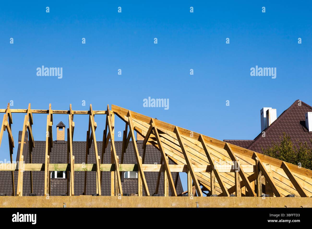Bau des Daches eines neuen Privathauses. Neue Holzbalken auf dem Dach des Hauses installiert. Stockfoto