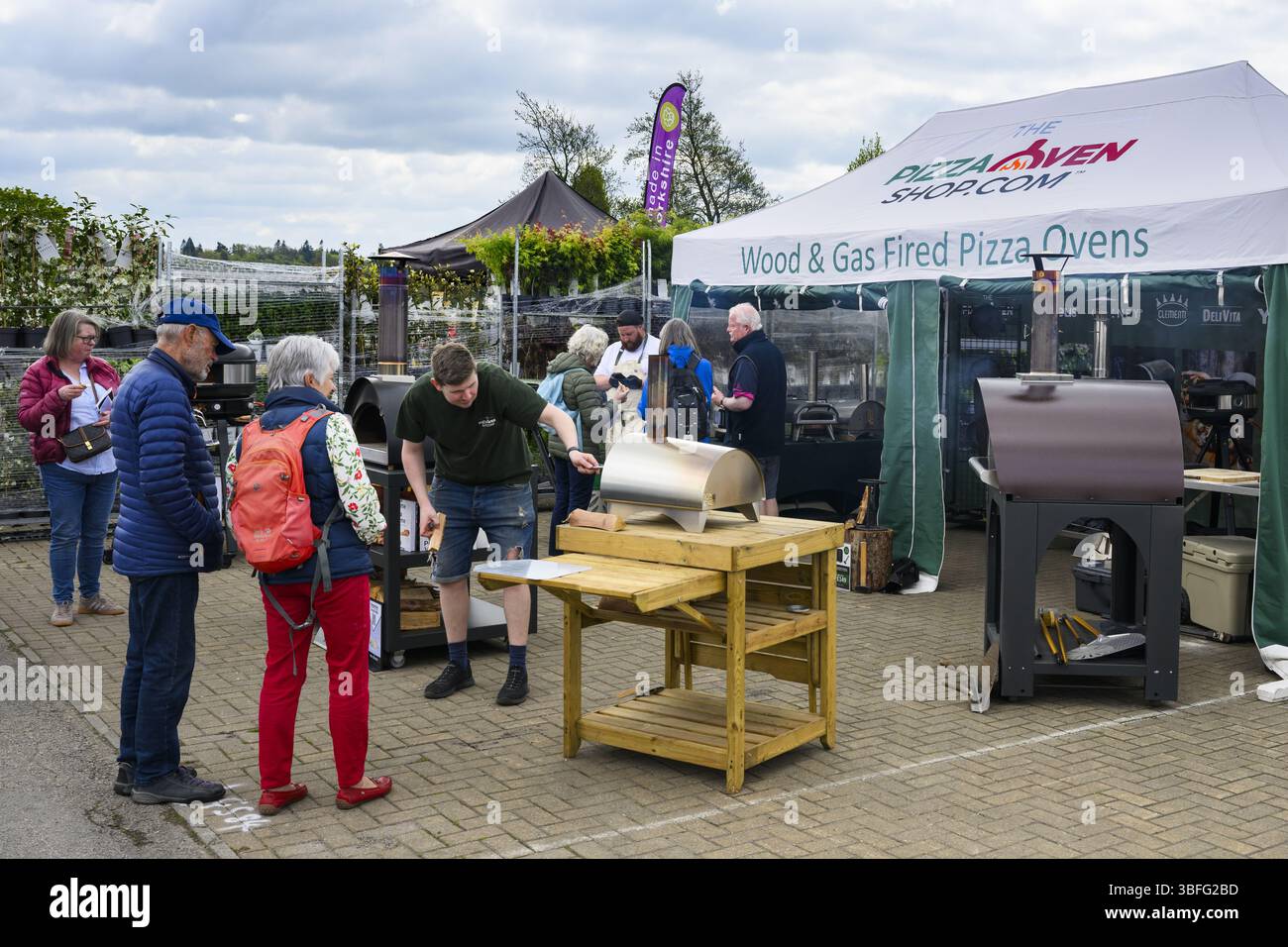 Ausstellungsstand für Pizzaöfen (Kunden stöbern, Verkäufer erklären dies) - Harrogate Spring Flower Show 2025, Yorkshire England, Großbritannien. Stockfoto