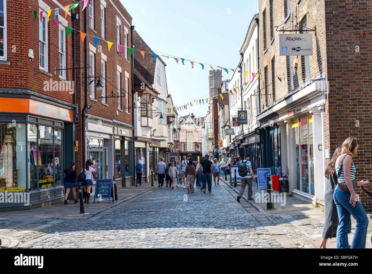 Canterbury, Kent, Großbritannien - 2. Mai 2025: Besucher spazieren durch die Kopfsteinpflasterstraßen im Dorf Canterbury, Heimat der beliebten Kathedrale von Canterbury. Stockfoto