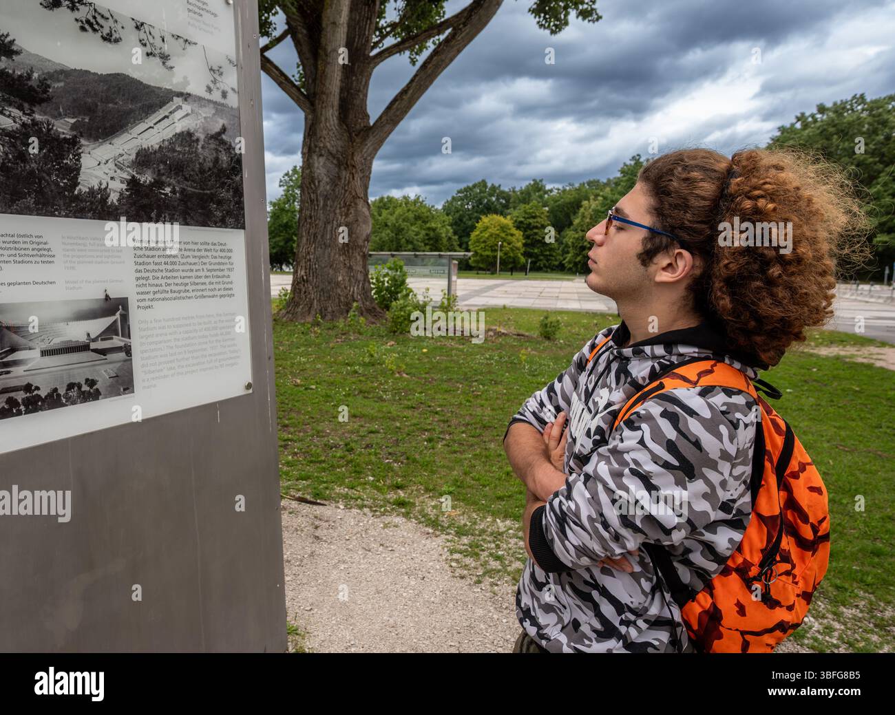 Nürnberg, Deutschland, 3. August 2023. Ein junger kaukasischer Mann mit lockigen Haaren und Brille schaut sich Informationsschilder an der NS-Parteikundgebung an. Stockfoto